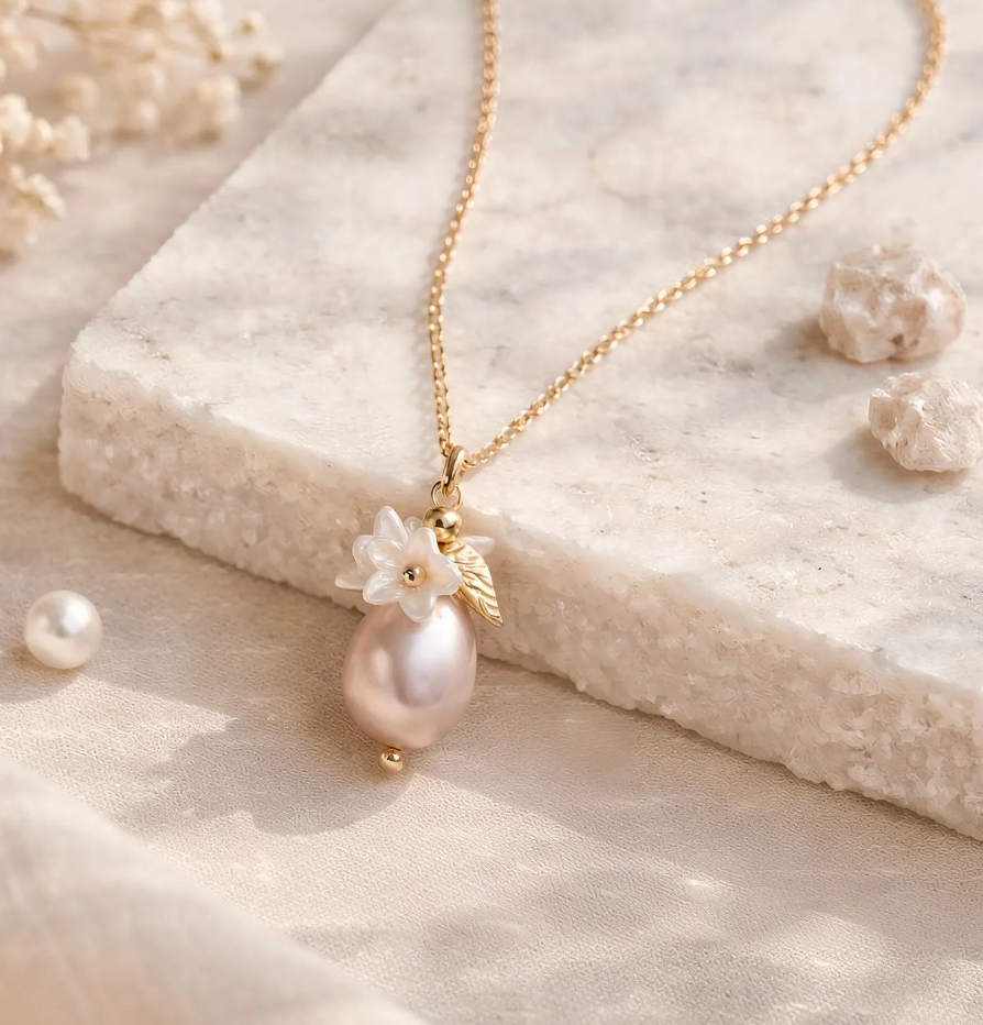 Pearl necklace with floral pendant on a textured beige surface